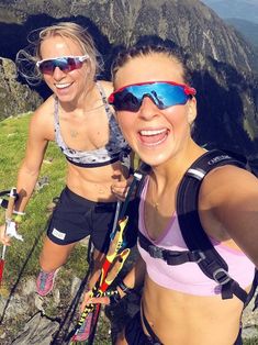 two young women standing on top of a mountain