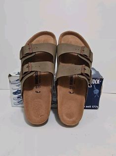 Experience the comfort and style of the Birkenstock AriZona Sandal in size 44. This classic sandal features a solid pattern, flop character, and brown color that makes it perfect for casual occasions during the summer and spring season. The sandal is made with high-quality leather upper material and cork insole material for a durable and comfortable fit. The Birkenstock AriZona Sandal also comes with straps and adjustable features that allow for a secure and customizable fit. This sandal is a must-have for any man's shoe collection and is part of the Birkenstock Arizona product line. Get your hands on this stylish and comfortable sandal today! Casual Footbed Sandals With Ortholite Insole For Vacation, Casual Footbed Sandals With Ortholite Insole For The Beach, Brown Slide Flip Flops With Cushioned Footbed, Brown Slides With Arch Support For Vacation, Casual Flat Flip Flops With Ortholite Insole, Casual Flip Flops With Leather Footbed, Brown Footbed Sandals With Arch Support For Outdoor, Brown Outdoor Footbed Sandals With Arch Support, Outdoor Brown Footbed Sandals With Arch Support