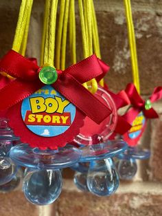 the toy story bell bells are hanging from strings with red ribbon and bows on them