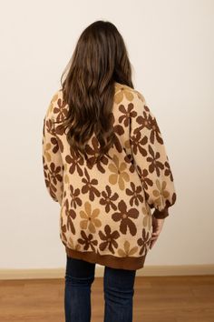 This unlined cardigan features a button-front closure, making it easy to layer over various outfits. The balloon sleeves add a touch of modern elegance, enhancing the overall design with a flattering and dramatic silhouette. The rich brown floral pattern adds a charming detail, making this cardigan a versatile piece for both casual and semi-formal occasions. Ideal for layering in cooler weather, it provides both warmth and a stylish, comfortable fit.Model & Fit Model: Tiffanee (5' 7" and Size 6 Retro Brown Oversized Outerwear, Retro Oversized Brown Outerwear, Brown V-neck Cardigan For Spring, Trendy Brown V-neck Cardigan, Oversized Puff Sleeve Sweater For Fall, Vintage Long Sleeve Cardigan For Fall, Brown V-neck Outerwear For Spring, Oversized Brown Cardigan For Spring, Oversized Button-up Cardigan For Fall