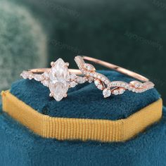 two wedding rings on top of a blue velvet hat with gold band and diamond accents