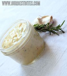 a jar filled with food sitting on top of a white towel next to a garlic plant