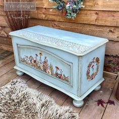 an old chest painted in blue with flowers on the front and sides, sitting on a wooden floor