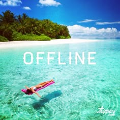 a woman floating on top of a pink surfboard in the ocean next to an island