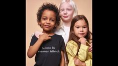 three children posing for a photo in front of a beige background with the words love is never blind