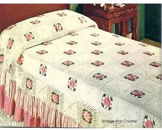 an old fashioned crocheted bedspread with pink flowers on it