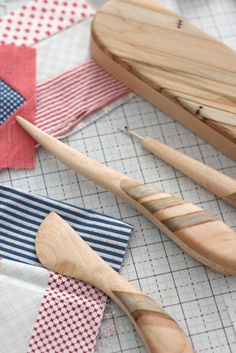 some wooden spoons are laying next to each other on a quilted table cloth