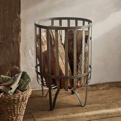 a basket filled with wood sitting on top of a wooden floor