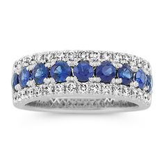 This 14-karat white gold band features traditional blue natural sapphires along the center with sparkling natural diamond borders. It offers a beautiful  bold look  making a gorgeous anniversary gift  wedding band  or daily accessory. Classic Blue Rings With Pave Setting, Classic Sapphire Rings With Pave Setting, Sapphire Diamond Ring With Pave Setting In White Gold, White Gold Sapphire Diamond Ring With Pave Setting, Classic Sapphire Ring With Pave Setting, Wedding Sapphire Diamond Ring With Pavé Setting, Blue Diamond Channel Set Ring, Blue Diamond Ring With Channel Set, Blue Diamond Ring With Channel Setting