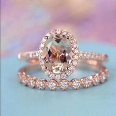 an engagement ring and wedding band set in rose gold with a large peach morganite