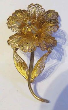 Extraordinary delicate beautifully designed signed Topazio Portugal brooch Gold washed sterling silver filigree comprises this breathtakingly beautiful jewellery.  This gorgeous flower brooch with leaves and stem is exquisite. The filigree is so fine, so perfect that it is a treasure. You will receive effusive compliments when you wear this lovely floral brooch. A fine accessory that exhibits good taste and excellent quality. Wear it on a jacket, dress, blouse or sweater. It also looks interesti Filigree Gold Jewellery, Vintage Yellow Gold Filigree Brooches, Antique Yellow Gold Filigree Brooches, Gold Victorian Brooch With Intricate Design, Victorian Gold Brooch With Intricate Design, Gold Victorian Brooches With Intricate Design, Victorian Gold Brooches With Intricate Design, Elegant Gold Filigree Brooches, Ornate Yellow Gold Wedding Brooch