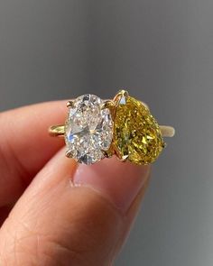 two yellow and white diamond rings in someone's hand