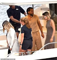 some people on a boat in the water and one person is standing near another woman