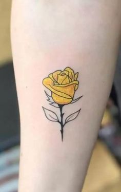 a small yellow rose tattoo on the leg