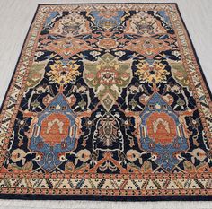 an antique persian rug with blue, orange and yellow colors on the middle is laying on a white floor