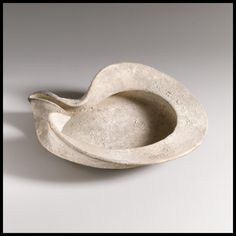 there is a white bowl with a bird shaped handle on the bottom and one side