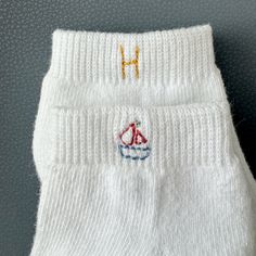 Custom sailboat embroidery socks done by hand! The stitch will be place on the outside of each sock.  The color of the threads is what is pictured. The cusomization is the initial.  Socks are from old navy! They are ankle  Socks are listed as one pair (2 socks) PLEASE NOTE all initials will be capitalized and only ONE letter per order. Shown in pictures above. because of the size of 0-6 months socks, the stitches will go below the ankle band Hand Embroidery Sailboat, Handmade White Socks For Gifts, Handmade White Socks For Gift, Handmade White Socks As Gift, Sailboat Embroidery, Sock Embroidery, Onesie Diy, Embroidery Socks, Embroidered Socks