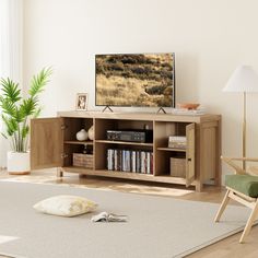 a flat screen tv sitting on top of a wooden entertainment center in a living room