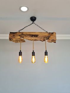 three light bulbs hanging from a wooden beam