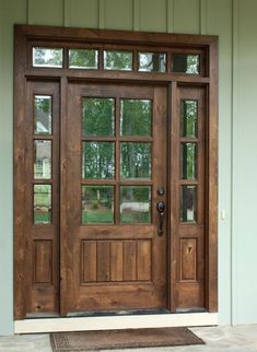 a wooden front door with glass panes