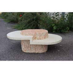 a stone bench sitting on top of a gravel road