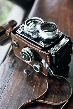 an old camera sitting on top of a wooden table