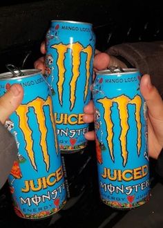 three people holding cans of juice in their hands