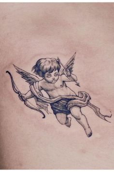 an angel tattoo on the back of a woman's stomach, holding a bow and arrow