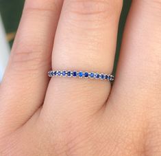 "Half Eternity Band Ring with Natural Blue Sapphires. MaterialSolid Gold (14K/18K) or Platinum 950 FinishHigh Polished/ Shiny PlatingRhodium/ Platinum Family (Only if white gold selected) FitComfort Fit/ Rounded Interior Width2mm Height2mm SettingU Micro Pave (Reminds the letter \"U\" from sides) StoneNatural Blue Sapphire QualityAAA Shape & CutRound, Diamond Cut Stone Size1.7 mm Total Carat Weightapx 0.35 ct Quantity of Stonesapx 18 (varies by ring size) Click below to add laser engraving. Blue Sapphire Eternity Band As Gift, Blue Round Eternity Band With Prong Setting, Blue Sapphire Eternity Band For Promise Ring, Blue Round Eternity Band For Anniversary, Blue Sapphire Stackable Rings For Anniversary, Blue Sapphire Eternity Band With Prong Setting, Blue Sapphire Ring With Half Eternity For Gift, Blue Round Cut Eternity Band For Anniversary, Blue Sapphire Half Eternity Ring As Gift