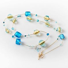 "Length: 88 cm / 34,64 \" Weight: 100 gr / 0,22 lb Classic tradition of this necklace is captured by the unique beads of different shapes: a succession of aquamarine glass squared and rounded beads, covered by precious gold leaf and \"sommerso\" in crystal, alternating with small spheres. The modern touch is given by the small crystals framing each bead, giving them additional light. This necklace, with its bright colours, is perfect for any style and fashion: its light composition makes it the Long Glass Beaded Chain Necklace, Elegant Turquoise Glass Beaded Necklace, Elegant Turquoise Long Necklace For Gift, Glass Beaded Chain Long Necklace, Elegant Czech Glass Long Necklaces, Long Czech Glass Necklace, Blue Single Strand Murano Glass Necklace, Murano Glass Single Strand Necklace As Gift, Single Strand Murano Glass Necklace For Gift