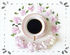 a cup of coffee surrounded by pink flowers