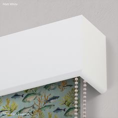 a close up of a white shelf with fish on it and beaded trim around the edge