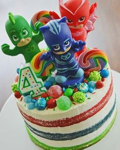 a birthday cake decorated with toy figures and candies