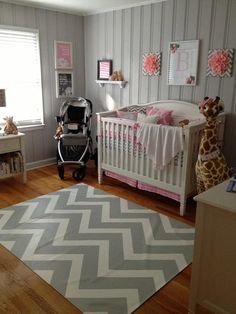 a baby's room with gray and pink decor