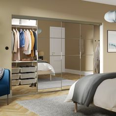 an image of a bedroom setting with clothes on hangers and closets in the background