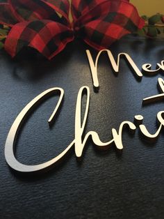 a merry christmas sign with a red bow on it's head and the words merry christmas written in cursive font