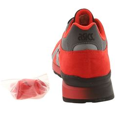 a pair of red and grey shoes next to a plastic bag