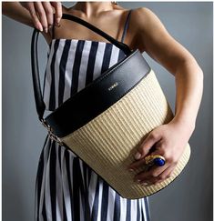 Be it an outdoor party or a picnic on your agenda, X NIHILO’s Picnic bag is perfect for brining your items – and a little personality – to your table. The bag features a main compartment to easily carry picnic goods or bottles in style. Made from vegan leather and woven raffia straw, it’s trimmed with a beautiful black leather, topped with a gold finish and removable, padded top handle strap. The interior is lined with insulated material and a top zip closure. Spring Leather Bucket Bag With Large Capacity, Trendy Summer Straw Bag With Detachable Strap, Trendy Bucket Bag With Detachable Handle, Trendy Natural Bucket Bag With Detachable Strap, Spring Large Capacity Basket-shaped Bucket Bag, Summer Straw Bag With Detachable Handle For Day Out, Summer Straw Bag With Detachable Strap For Spring, Spring Bucket Bag With Detachable Strap, Chic Bucket-shape Shoulder Bag With Bamboo Handle