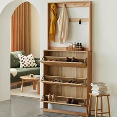 a wooden shoe rack sitting next to a green couch