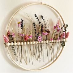 an embroidery hoop with flowers hanging on it