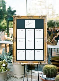 a table with a sign and potted plants