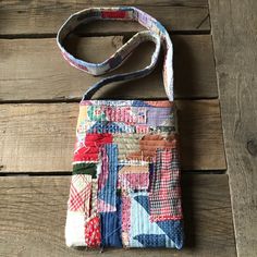 a multicolored patchwork purse sitting on top of a wooden floor