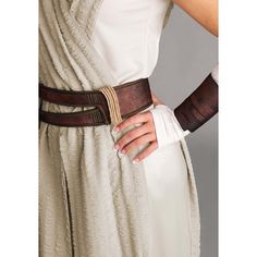 a woman wearing a white dress and brown belt with her hands on her hip,