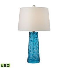 a blue glass lamp with a white shade