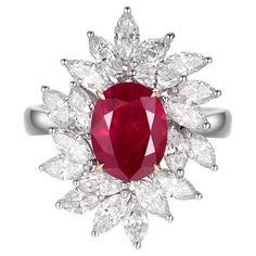 Emanating an air of timeless elegance, this Ruby Diamond ring is a mesmerizing fusion of luxury and sophistication. Meticulously set in a gleaming 18 karat white gold setting, every element of this piece accentuates its regal aura. Taking center stage is a heated Burma Ruby, known for its unparalleled brilliance and deep, romantic hue. Weighing an impressive 2.11 carats, this ruby is not just a gemstone, but a piece of history, sourced from the famed mines of Burma, recognized for producing some of the world's most sought-after rubies. Complementing the fiery radiance of the ruby are marquise diamonds, with a collective weight of 2.21 carats. These diamonds, with their elongated shape and pointed ends, add a touch of vintage charm and shimmer, creating a captivating contrast to the warmth Luxury Gold Marquise Ruby Ring, Luxury Flower-shaped Ruby Ring, Deep Romantic, Ruby Diamond Ring, Luxury Ring, Ruby Diamond Rings, Luxury Rings, Marquise Diamond, Ruby Diamond