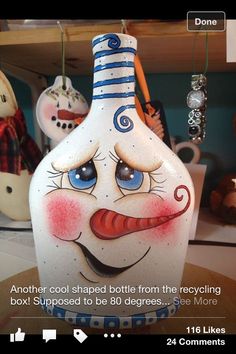 a vase with a face painted on it sitting on a table next to other items