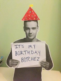 a man with a birthday hat holding a sign