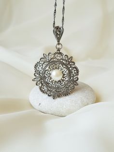 This 925 Sterling Silver Floral filigree pendant is purely handmade and natural Freshwater Pearl is used in the middle. Filigree (Telkari) was a traditional handcraft in Anatolia and Mesopotamia, and still being one of the most important artisan styles in some regions of Turkey, especially in Ankara. Filigree is a kind of jewelry metalwork of silver and gold. Tiny beads and twisted threads are soldered together and arranged in different artistic motifs by silvercraftsmen, thus creating perfectly Intricate Round Pendant Jewelry For Anniversary, Silver Filigree Bridal Necklace For Formal Occasions, Formal Silver Filigree Bridal Necklace, Ornate Silver Necklace With Pearl Pendant, Antique Silver Jewelry With Pearl Pendant, Filigree Round Pendant Necklace For Anniversary, Victorian Silver Jewelry With Pearl Pendant, Intricate Pendant Jewelry For Anniversary, Silver Antique Jewelry With Pearl Pendant