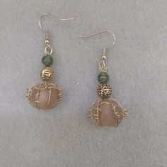 Frosted, translucent baroque soft pumpkin orange beads caged with gold wire tendrils. They fall below an intricately molded gold bead that is topped by a small green glass bead that catches light with its subtle sparkly swirls.  I think they would be perfect for an enchanted evening in October! Gold Aventurine Beaded Jewelry, Unique Wire Wrapped Beaded Earrings With Round Beads, Unique Gold Wire Jewelry, Wire Wrapped Copper Beaded Dangle Earrings, Unique Gold Wire Wrapped Earrings, Bronze Wire Wrapped Czech Glass Earrings, Bronze Wire Wrapped Earrings With Czech Glass, Bronze Wire Wrapped Drop Earrings, Unique Wire Wrapped Beaded Drop Earrings