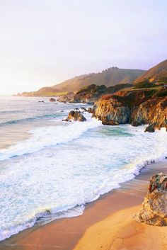 the beach has waves coming in and out of the water on it's shore